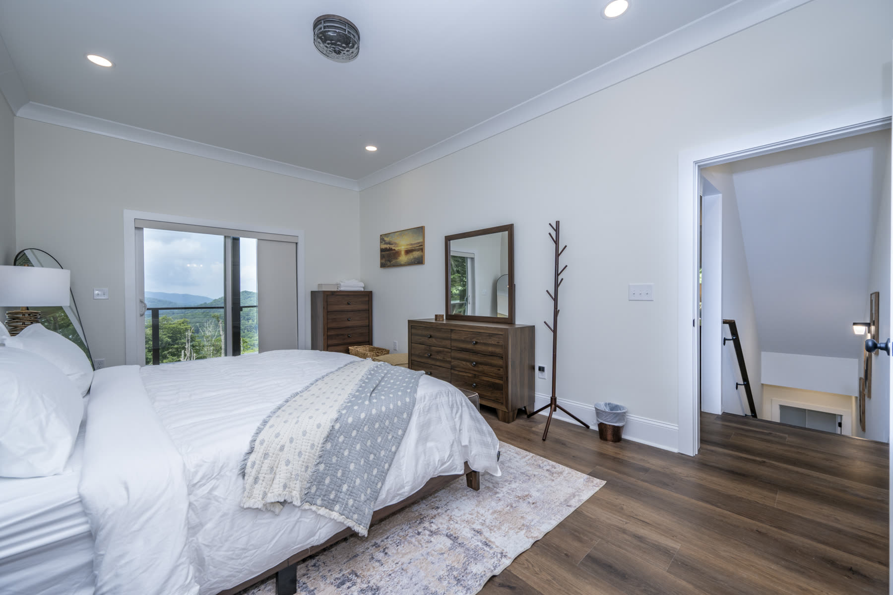 Bedroom with a queen bed and sliding glass door leading to a private balcony