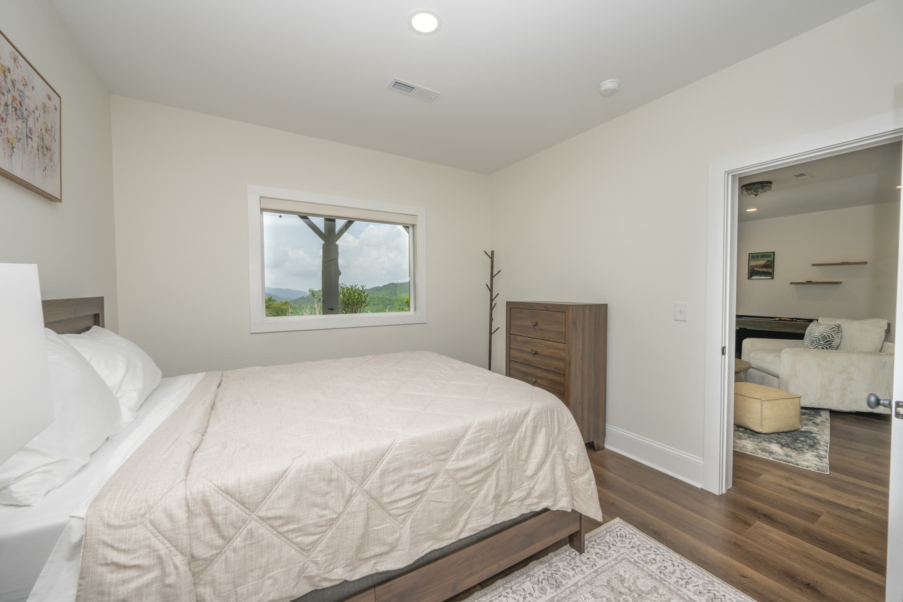 Bedroom doorway opening into a bright upstairs lounge with a cream sofa
