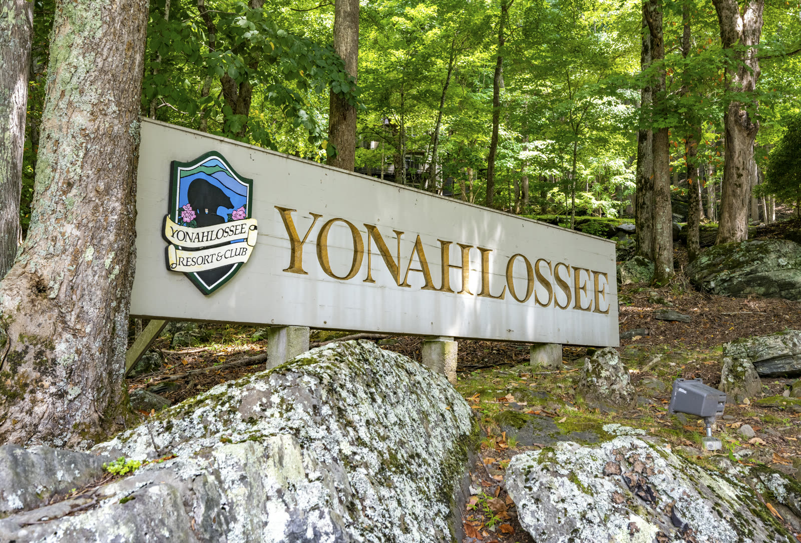 Wooden entrance sign for Yonahlossee Resort and Club, set among trees