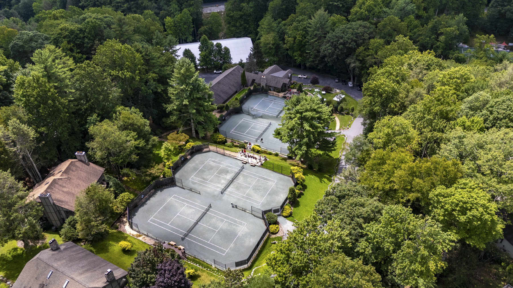 Aerial view of the Yonahlossee Racquet Club's tennis courts surrounded by forest
