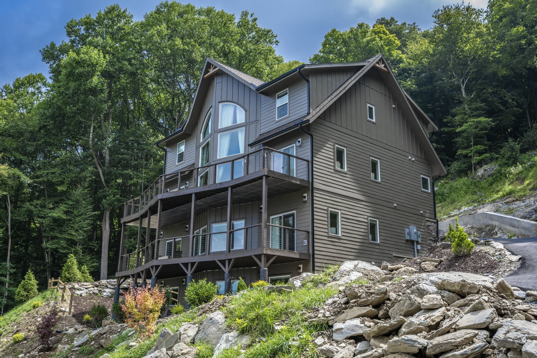 Mountain home exterior with a tall timber-frame gable and arched picture window